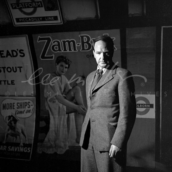 Black and white. Close up portrait with backdrop of advertising posters.